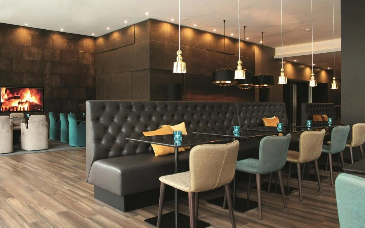 a restaurant with a table and chairs and a fireplace at Motel One Manchester-Piccadilly in Manchester